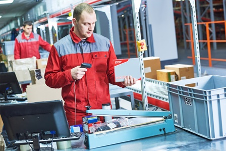worker with laser barcode scanner at warehouse
